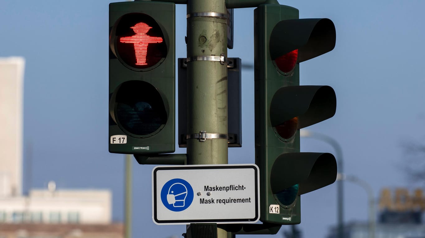 Ein Schild mit dem Hinweis der Maskenpflicht ist an einer Ampel in Berlin aufgehängt (Symbolbild): In der Hauptstadt könnten die Corona-Maßnahmen schnell verschärft werden.