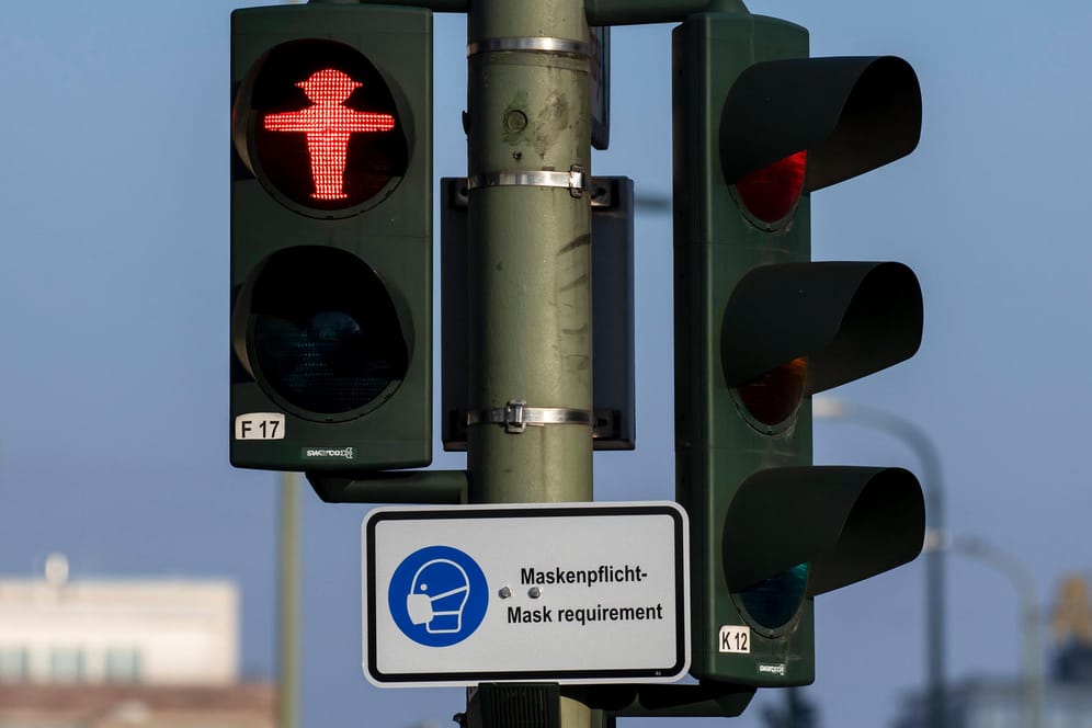 Ein Schild mit dem Hinweis der Maskenpflicht ist an einer Ampel in Berlin aufgehängt (Symbolbild): In der Hauptstadt könnten die Corona-Maßnahmen schnell verschärft werden.