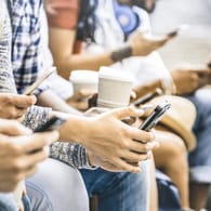 Menschen mit Smartphones (Symbolbild): Die EU-Kommission möchte Zugang zu verschlüsselten Daten.