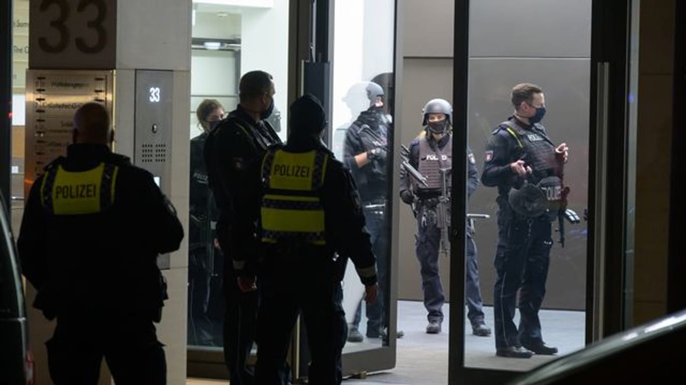 Schwer bewaffnete Polizisten stehen in und vor einem Bürogebäude: Eine bewaffnete Person wurde im Gebäude vermutet.