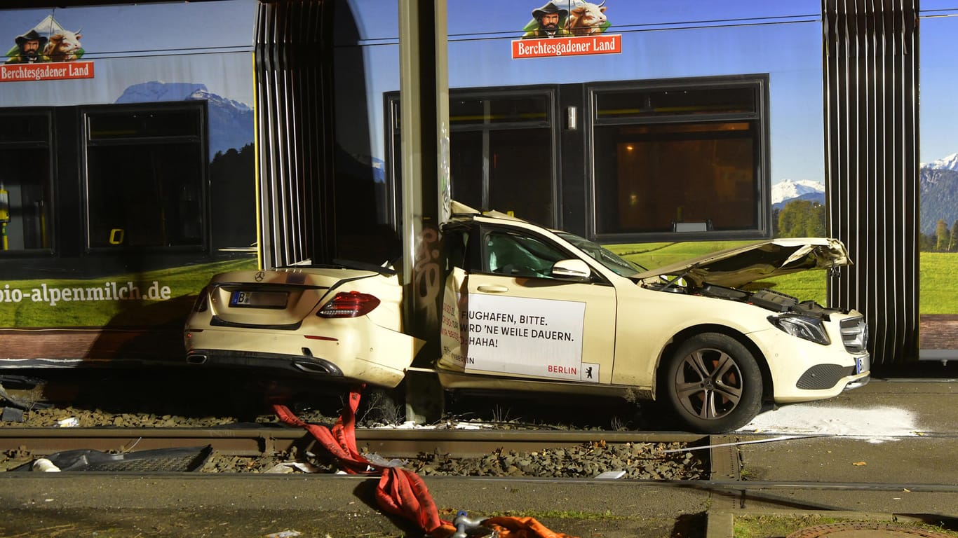 Ein Taxi steht nach einer Kollision mit einer Berliner Straßenbahn eingeklemmt zwischen einem Mast und der Straßenbahn am Unfallort: Bei dem Unfall wurde ein Mensch verletzt.