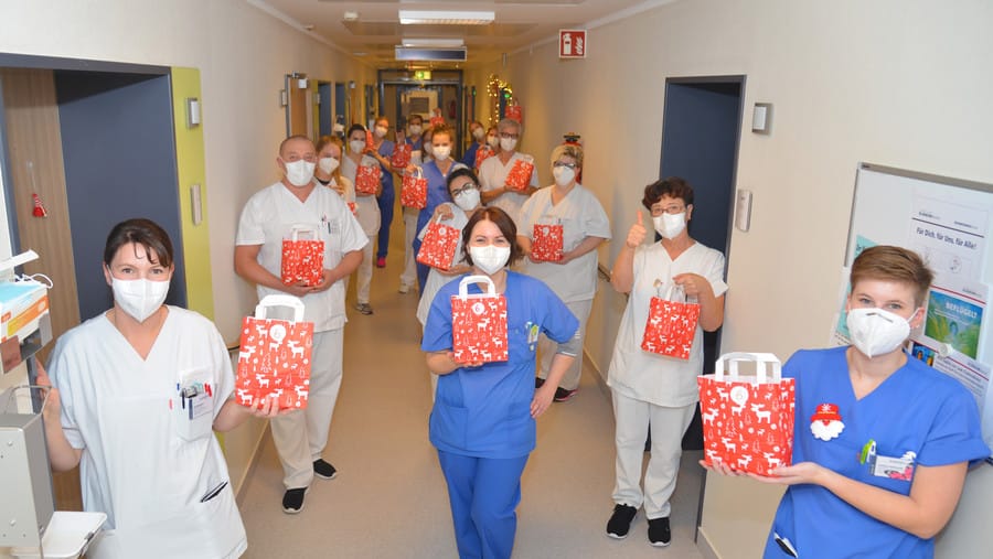 Mitarbeiter des Evangelischen Klinikums Bethel in Bielefeld halten Adventstüten in die Höhe: Diese wurden ihnen von einer dankbaren Patienten überreicht.