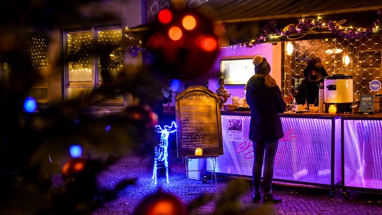 Eine junge Frau kauft sich einen Glühwein im Berliner Stadtteil Prenzlauer Berg: Eine Bar in der Stargarder Straße stoppt den Verkauf jetzt – freiwillig.