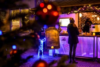 Eine junge Frau kauft sich einen Glühwein im Berliner Stadtteil Prenzlauer Berg: Eine Bar in der Stargarder Straße stoppt den Verkauf jetzt – freiwillig.