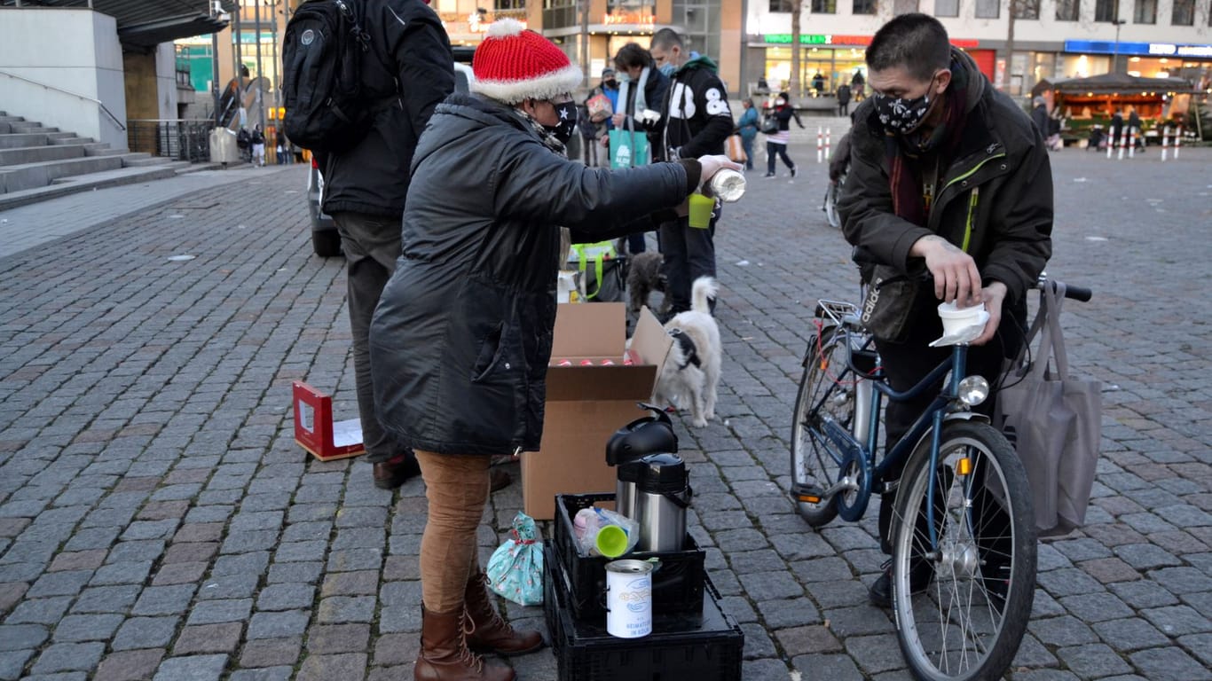 Eine Frau schenkt einem Obdachlosen ein heißes Getränk ein. In der Weihnachtszeit verteilt Linda Rennings auch Geschenke an die Obdachlosen.