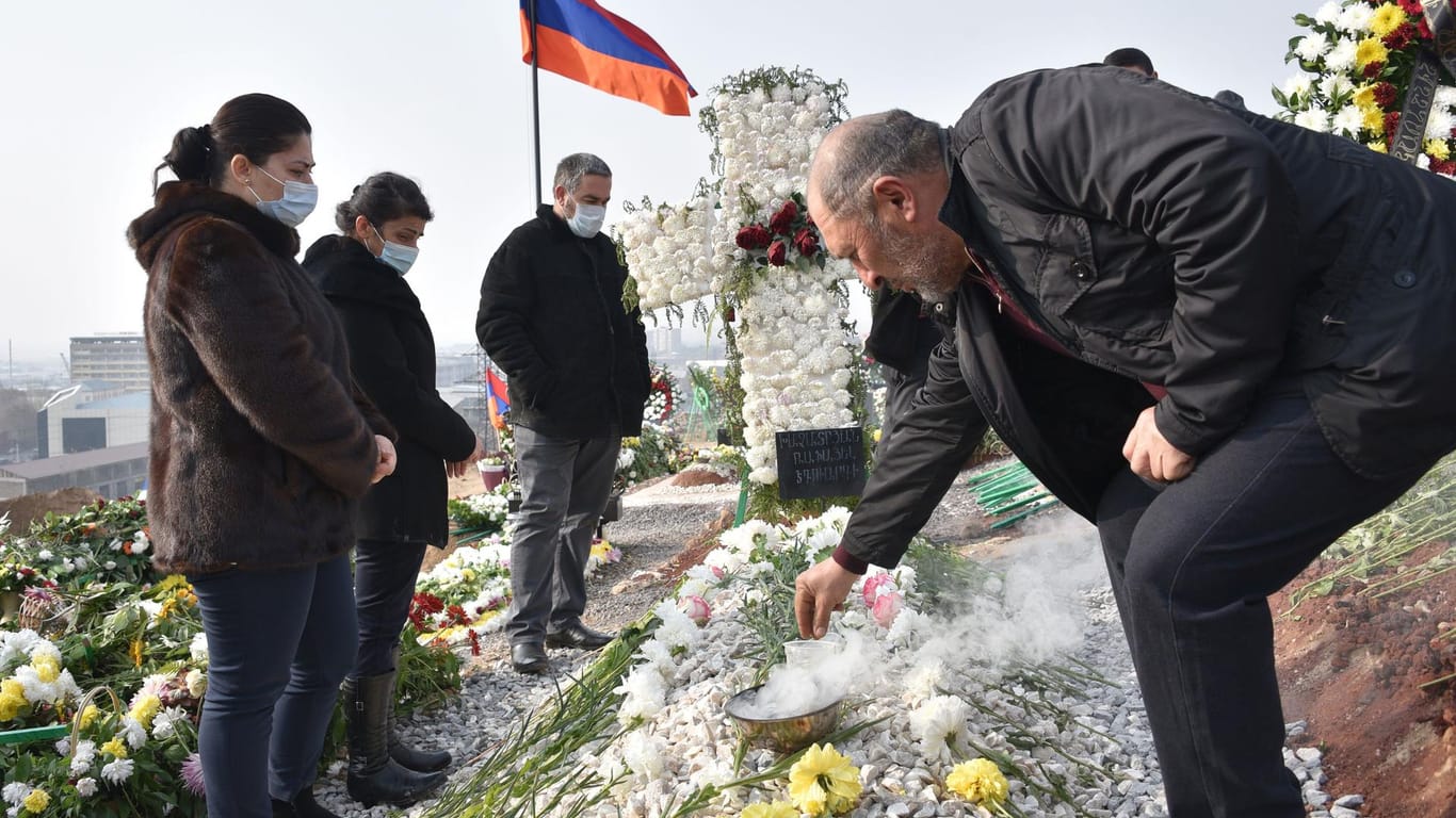 Menschen besuchen das Grab ihrer getöteten Verwandten in der armenischen Hauptstadt: Offenbar hat es wieder Kämpfe gegeben.