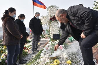 Menschen besuchen das Grab ihrer getöteten Verwandten in der armenischen Hauptstadt: Offenbar hat es wieder Kämpfe gegeben.