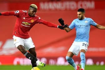 Uniteds Paul Pogba (l) im Duell mit Riyad Mahrez von Manchester City.