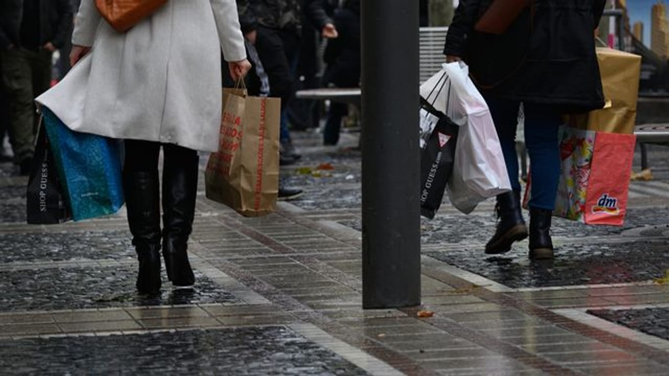 Menschen gehen mit vollen Einkaufstüten über eine Einkaufsstraße (Symbolbild): Vor dem Lockdown waren am Samstag in Stuttgart noch einmal besonders viele Menschen in der Innenstadt unterwegs.