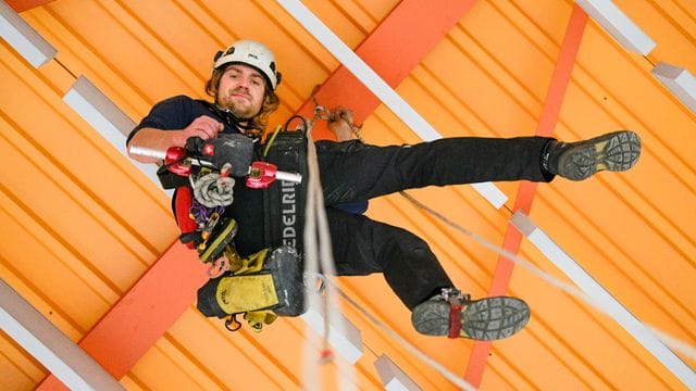 Safety first: Der Industriekletterer Manuel Driller ist mit Helm, Gurt, Karabinern, Seilen, Trägerklemmen, Sicherungsgerät, Abseilgerät und Erste-Hilfe-Tasche ausgestattet.