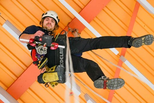 Safety first: Der Industriekletterer Manuel Driller ist mit Helm, Gurt, Karabinern, Seilen, Trägerklemmen, Sicherungsgerät, Abseilgerät und Erste-Hilfe-Tasche ausgestattet.