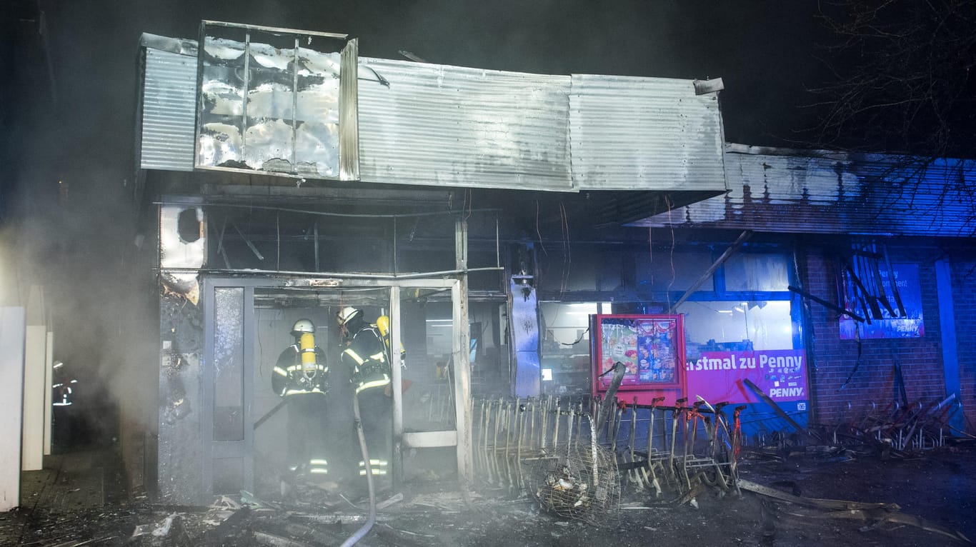 Feuerwehrleute sind im Hamburger Stadtteil Veddel während eines Brandes in einem Supermarkt mit Löscharbeiten beschäftigt: Dort hatte wohl der Überstand für die Einkaufswagen gebrannt und das Feuer ausgelöst.