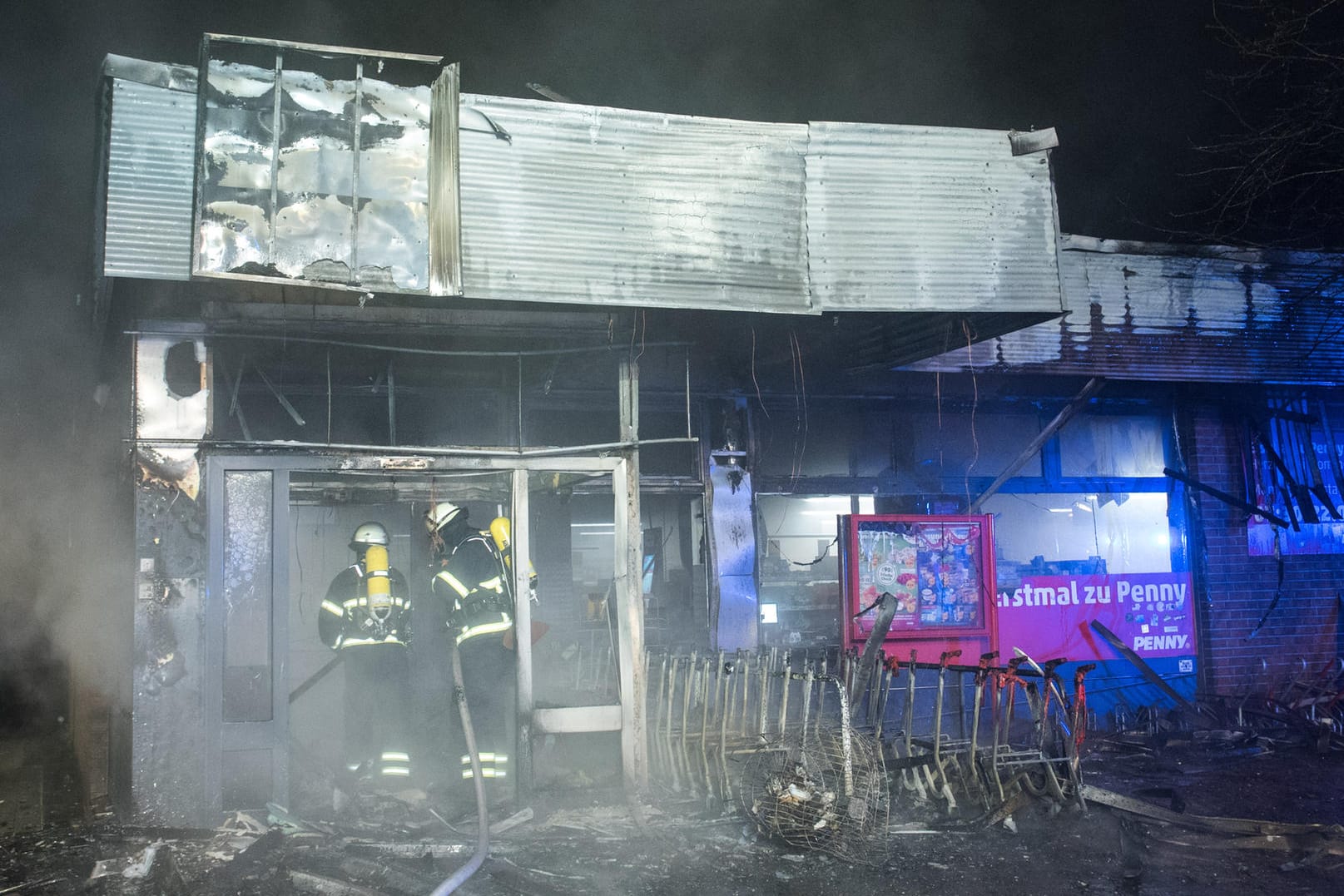 Feuerwehrleute sind im Hamburger Stadtteil Veddel während eines Brandes in einem Supermarkt mit Löscharbeiten beschäftigt: Dort hatte wohl der Überstand für die Einkaufswagen gebrannt und das Feuer ausgelöst. Feuerwehrleute sind im Hamburger Stadtteil Veddel während eines Brandes in einem Supermarkt mit Löscharbeiten beschäftigt: Dort hatte wohl der Überstand für die Einkaufswagen gebrannt und das Feuer ausgelöst.