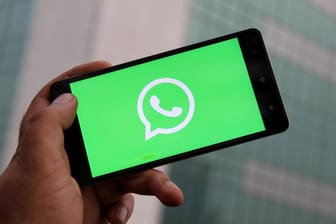 Das Logo von WhatsApp auf einem Smartphone (Symbolbild): Nutzer können beim Messenger ablaufende Nachrichten aktivieren.