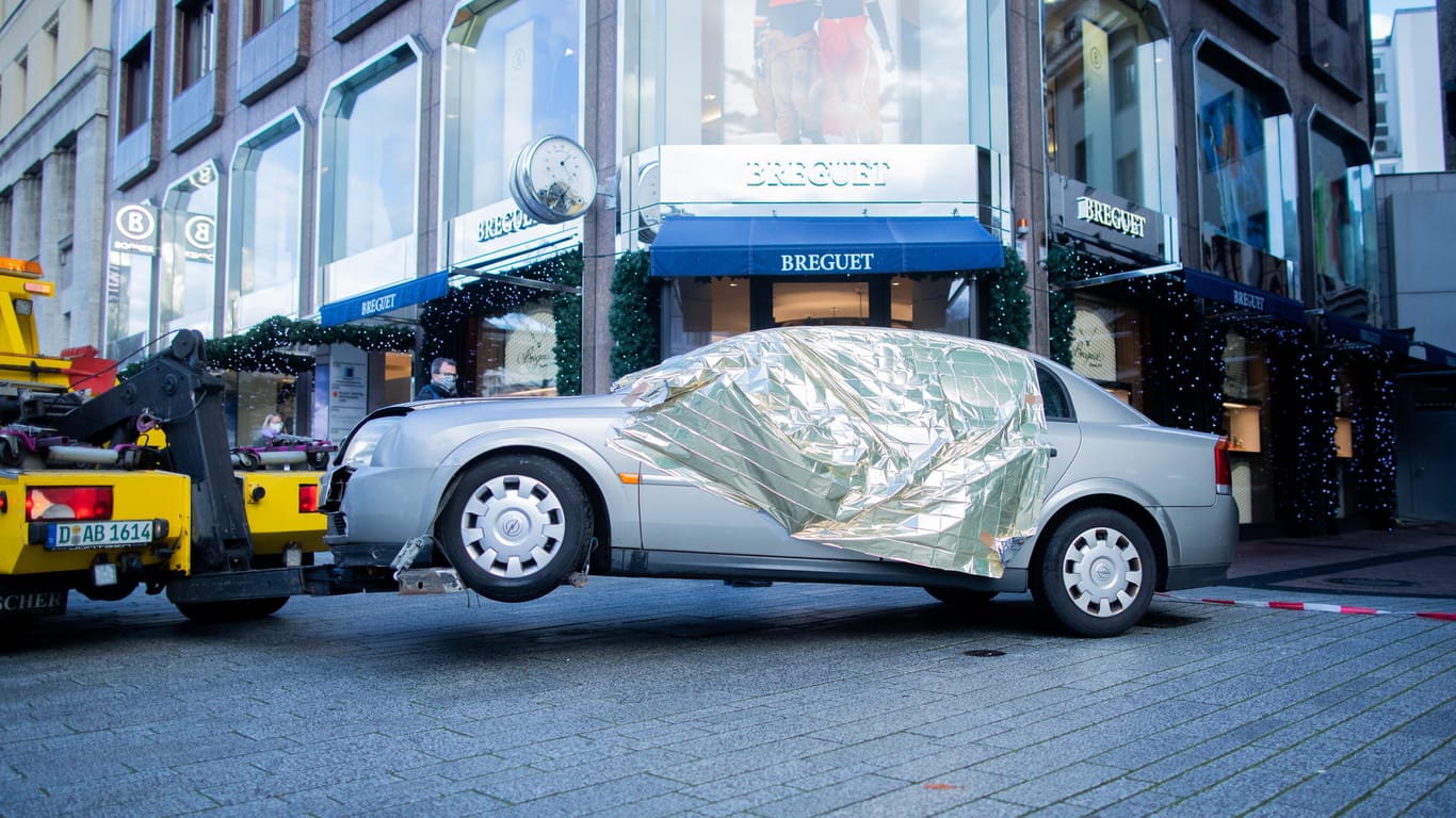 Das Tatfahrzeug wird nach einem Überfall auf eine Filiale der Schweizer Luxusuhrenmanufaktur Breguet über die Königsallee abgeschleppt: Die Polizei fahndet nach den Tätern.