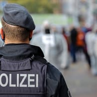 Ein Polizist von hinten (Symbolbild): In Dortmund hat ein Mann mehrere Unfälle verursacht.