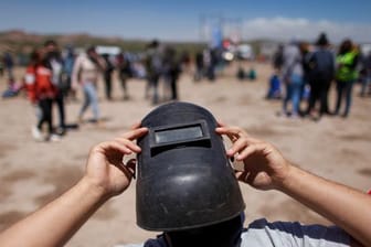 Mit einer Schweißermaske als Schutz wartet ein Mann im argentinischen Piedra Del Aguila auf eine totale Sonnenfinsternis.