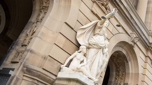 Vor dem Gerichtsgebäude hält eine Statue der Justitia eine Waagschale (Symbolbild): Nach einem Angriff bei einer Corona-Demo müssen sich zwei Männer vor Gericht verantworten. Vor dem Gerichtsgebäude hält eine Statue der Justitia eine Waagschale (Symbolbild): Nach einem Angriff bei einer Corona-Demo müssen sich zwei Männer vor Gericht verantworten.