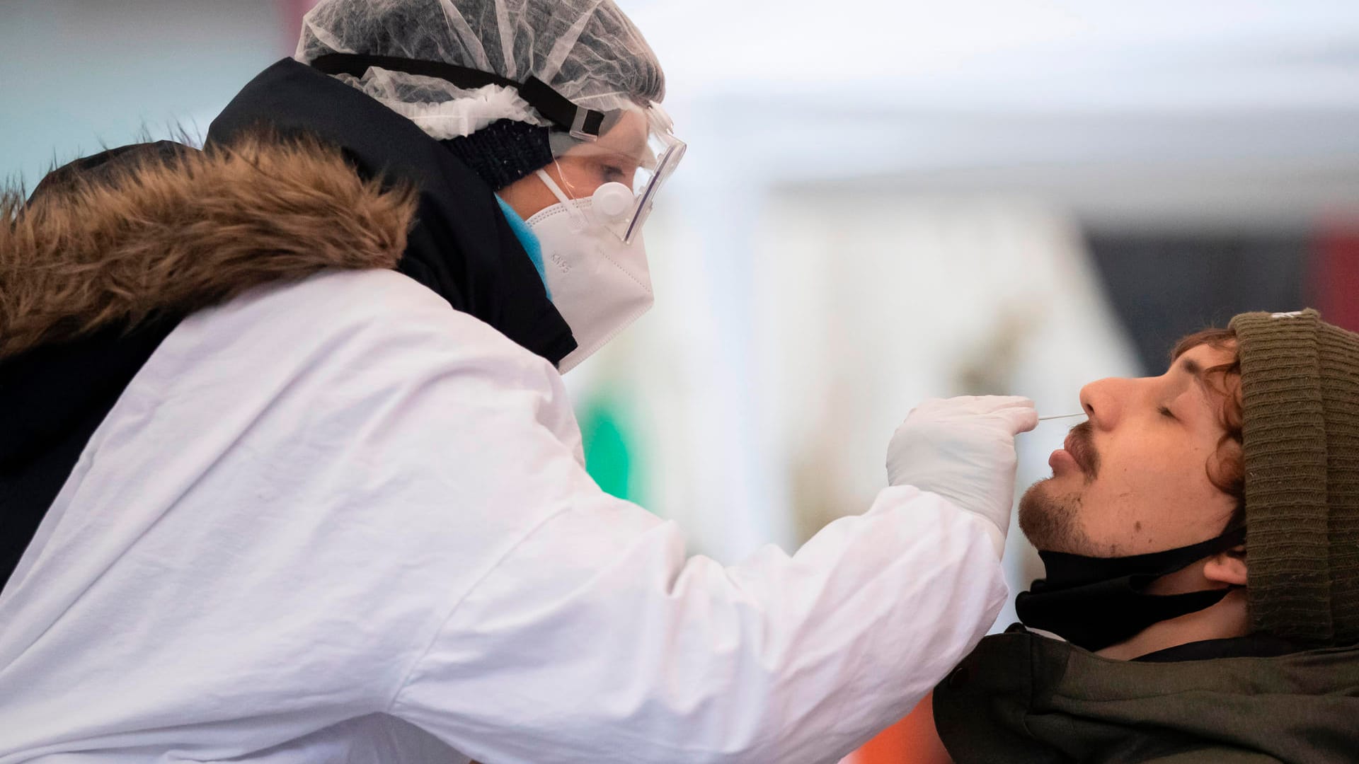 Tübingen: Ein Mann wird von einer Mitarbeiterin des Deutschen Roten Kreuzes (DRK) an der Corona-Schnellteststation abgestrichen.