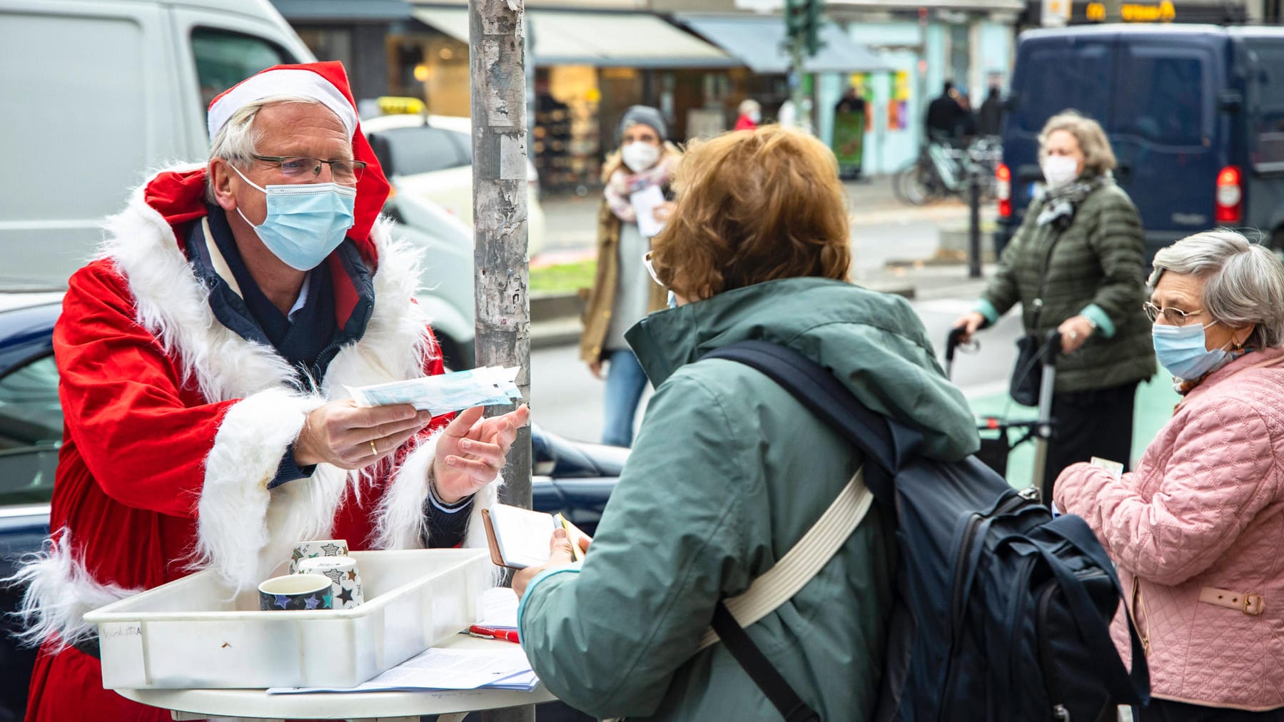 Menschen bei einer Verteilung von FFP2-Masken in Berlin: Risikogruppen können sich umsonst Masken von Apotheken abholen.