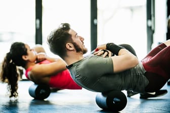 Sportler trainieren im Fitnessstudio (Symbolbild): Verträge fürs Fitnessstudio sollen künftig in der Regel nur noch ein Jahr laufen.