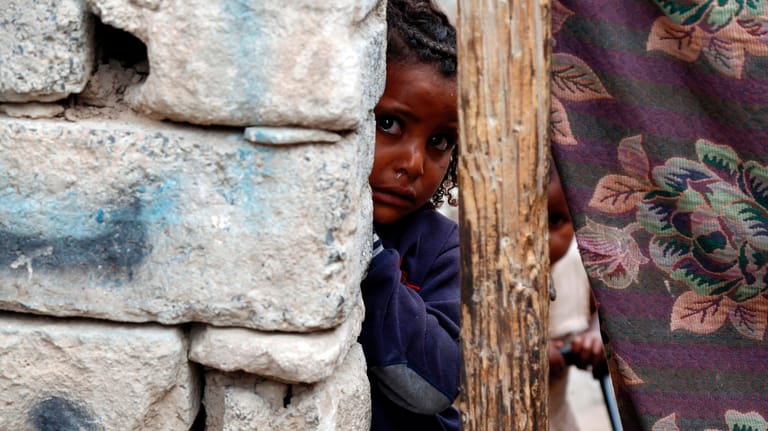 Ein kleines Mädchen blickt hinter einer Mauer in einem Slum eines Kriegsgebiets von Sanaa im Jemen hervor: Jemen das Land mit dem höchsten Risiko einer humanitären Notlage im Jahr 2021.