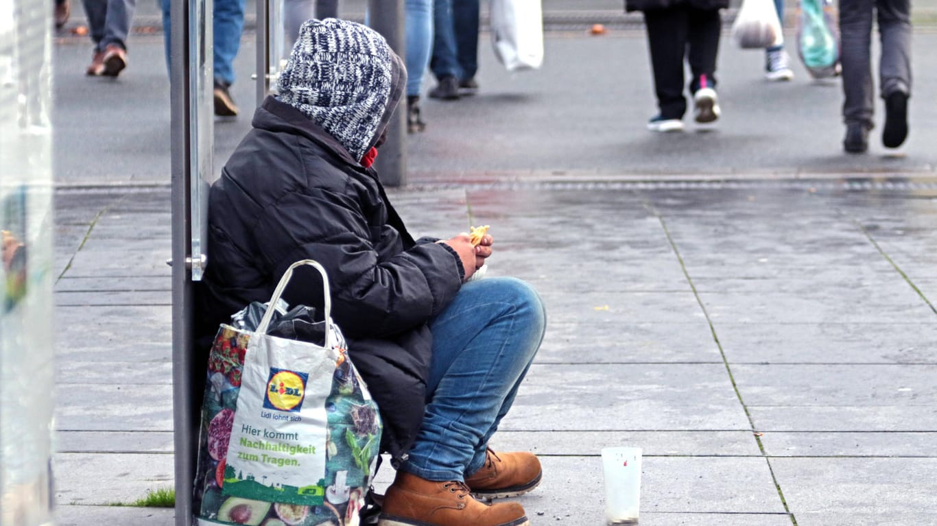 Eine obdachlose Person bittet in einer Einkaufsstraße um Geld (Symbolbild): Die kalte, teils lebensgefährliche Jahreszeit macht Wärme zwingend erforderlich. Deswegen startet in Wuppertal nun wieder die Kälte-Hotline.