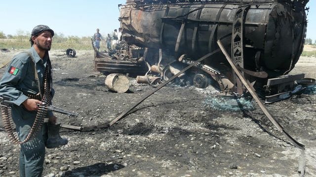Ein afghanischer Polizist steht vor einem ausgebrannten Tanklastzug in Kundus nach dem von dem deutschen Oberst Klein angeordneten Luftangriff. Ein afghanischer Polizist steht vor einem ausgebrannten Tanklastzug in Kundus nach dem von dem deutschen Oberst Klein angeordneten Luftangriff.