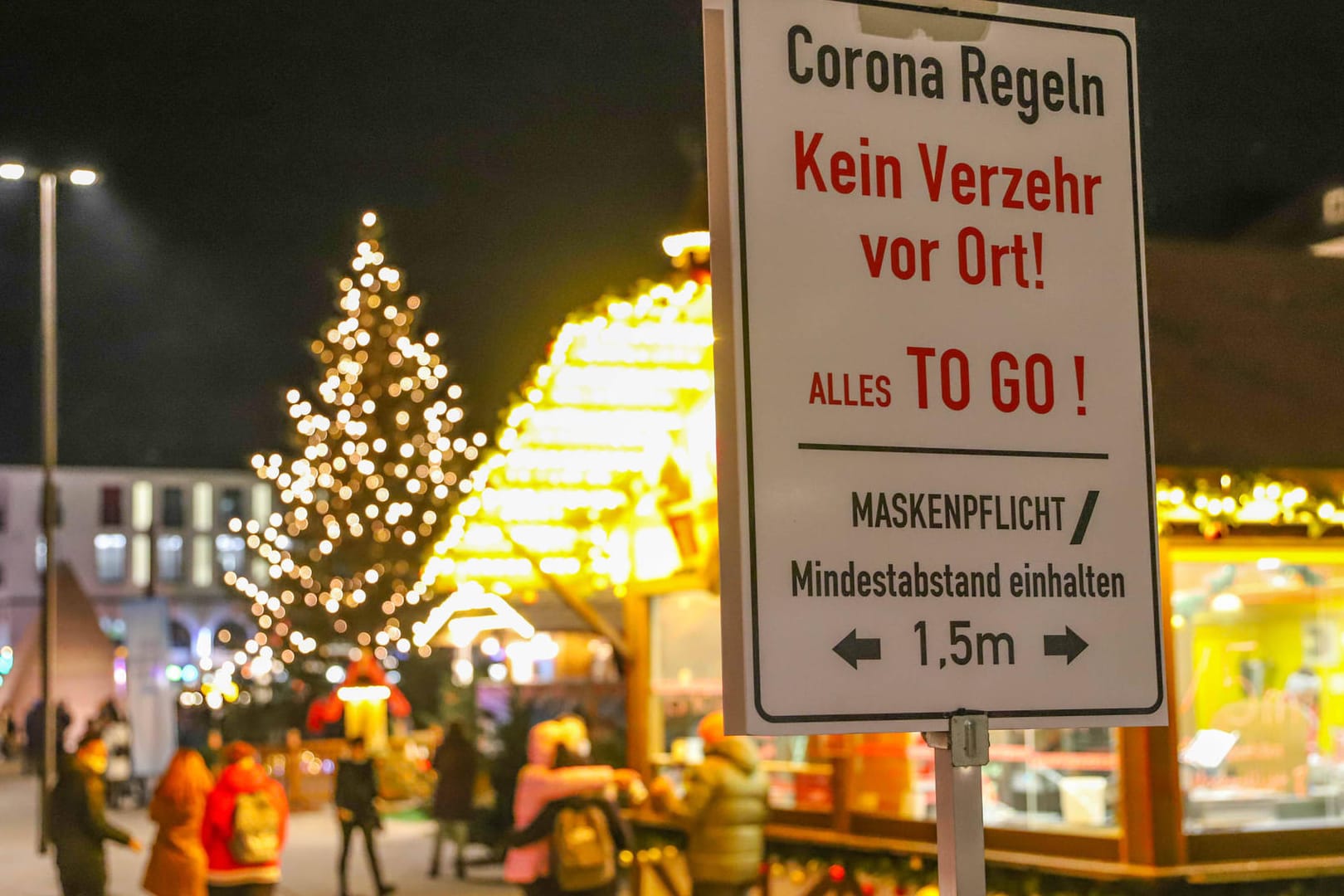 Ein Schild weist auf die Corona-Regeln an den Weihnachtsbuden in Karlsruhe hin (Archivbild): Nun mussten die Buden schließen.