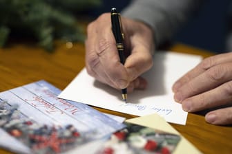 Eine Weihnachtskarte schreiben: Die Karten sollen pünktlich zu Weihnachten ankommen (Symbolbild).