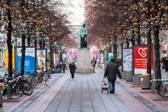 Passanten laufen durch die beinahe menschenleere Innenstadt von Hannover.