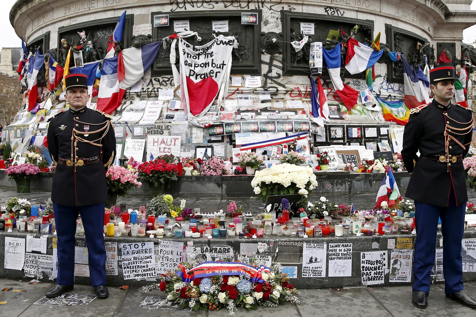 Gedenken an die Anschlagsopfer: Polizisten stehen am 10. Januar 2016 auf dem Place de la Republique vor Blumen, Kerzen und Botschaften, die Trauernde hinterlassen haben.