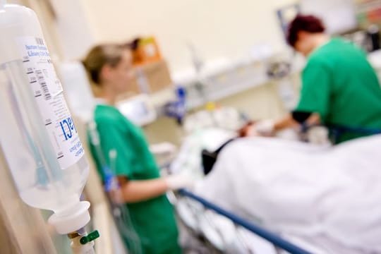 Medizinisches Personal versorgt im Krankenhaus einen Patienten (Symbolbild): Viele Krankenhausmitarbeiter haben Angst, Angehörige mit dem Coronavirus zu infizieren.