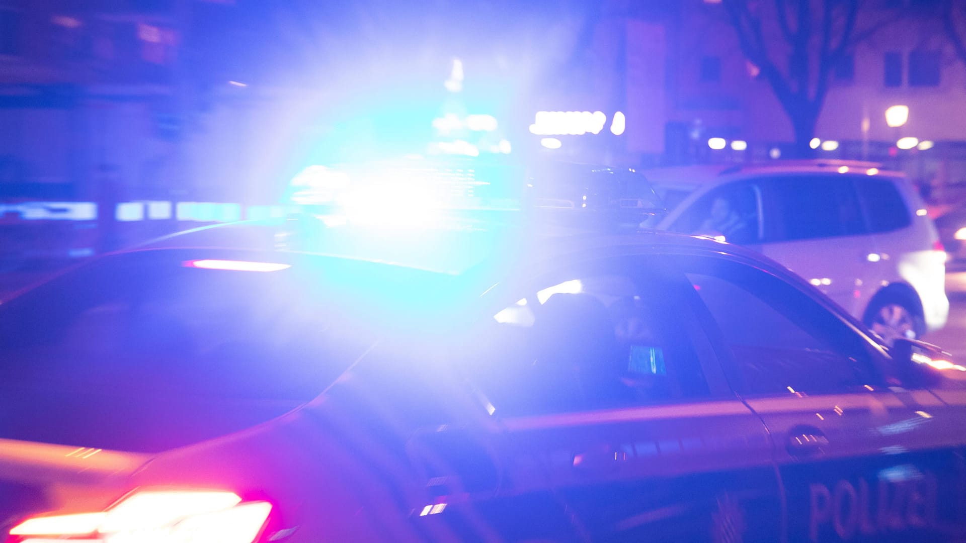 Ein Polizeiauto fährt mit Blaulicht durch die Nacht (Symbolbild): Ein Mann hat einen anderen Mann in Köln mit einer Pistole bedroht. Ein Polizeiauto fährt mit Blaulicht durch die Nacht (Symbolbild): Ein Mann hat einen anderen Mann in Köln mit einer Pistole bedroht.