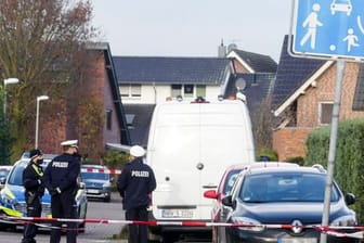 Polizisten stehen in der Nähe des Hauses, in dem ein Familienvater seine Ehefrau, eine der beiden gemeinsamen Töchter und schließlich sich selbst getötet haben soll.