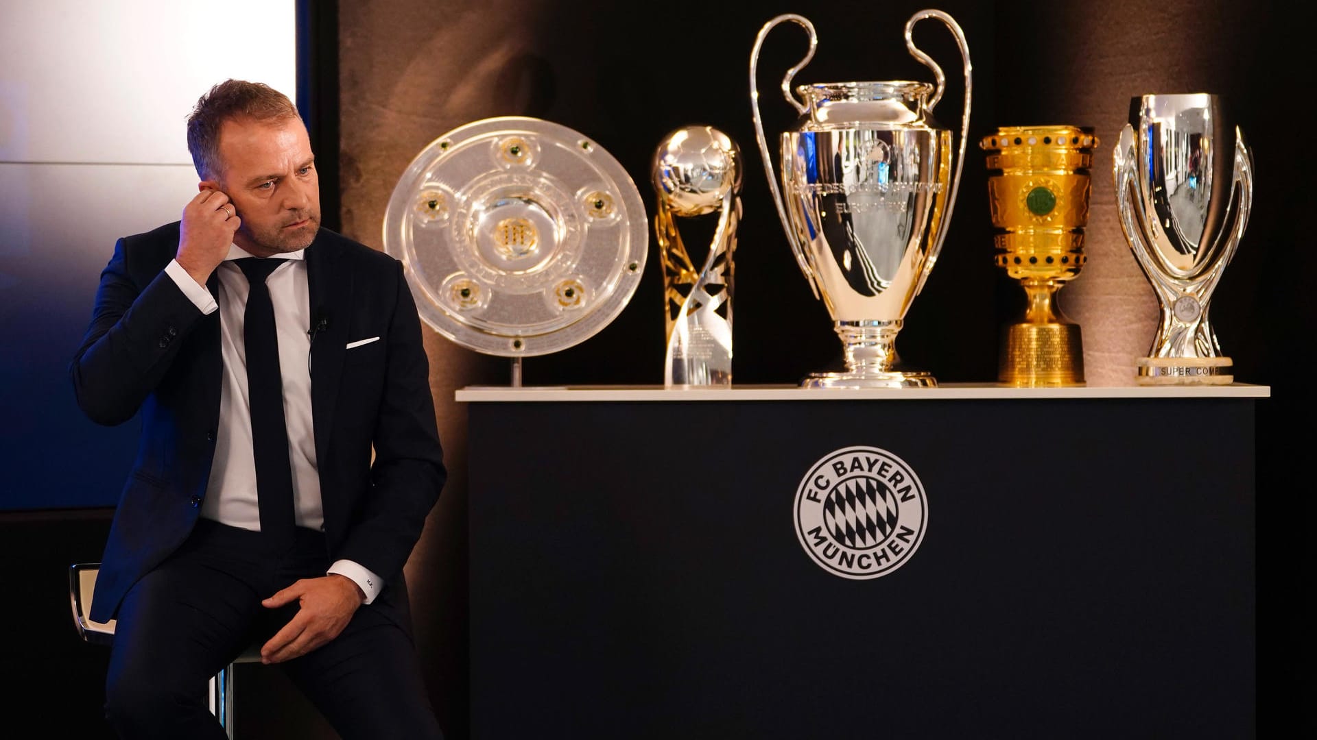 Hansi Flick sitzt vor zahlreichen Pokalen: Der Trainer gewann mit dem FC Bayern 2020 jeden möglichen Titel.