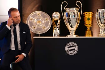 Hansi Flick sitzt vor zahlreichen Pokalen: Der Trainer gewann mit dem FC Bayern 2020 jeden möglichen Titel.