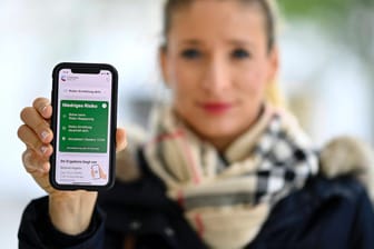 Eine Frau zeigt die Statusanzeige in der Corona-Warn-App: Die App hat ein größeres Update erhalten, das für Verwunderung sorgt.