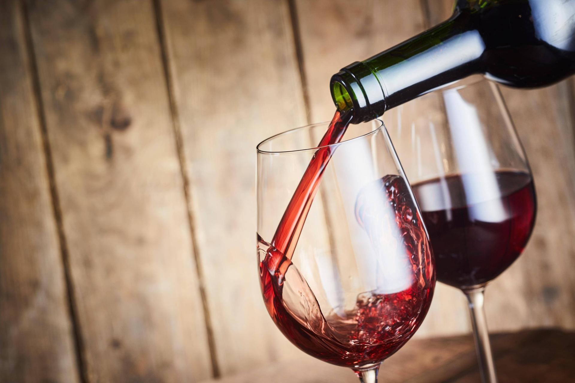 A glass of dry red wine being poured from a bottle Copyright: xfoodandmorex Panthermedia27403518
