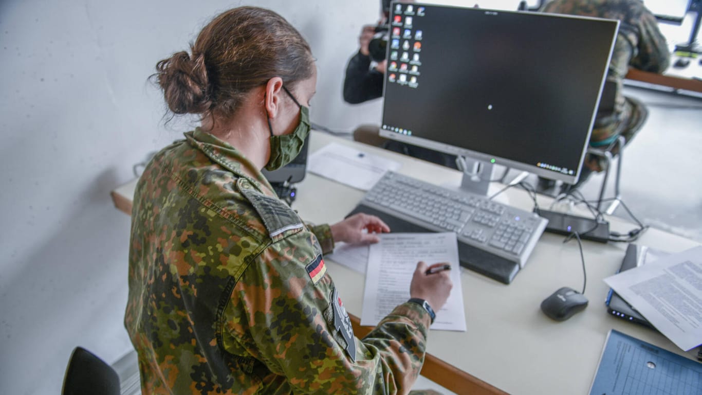 Eine Soldatin der Bundeswehr sitzt an einem Schreibtisch (Symbolbild): Für vier Wochen wird das Gesundheitsamt in Kiel von der Bundeswehr unterstützt.