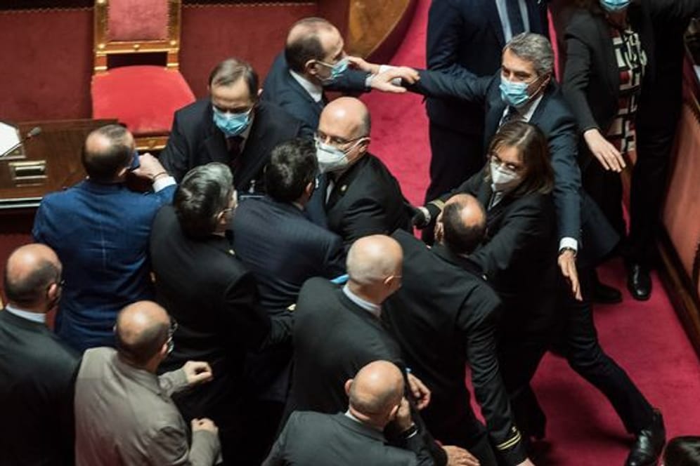 Platzanweiser (M) verhindern, dass Senatsmitglieder der Lega Nord (l) mit Mitgliedern der Demokratischen Partei im Senat aneinandergeraten.