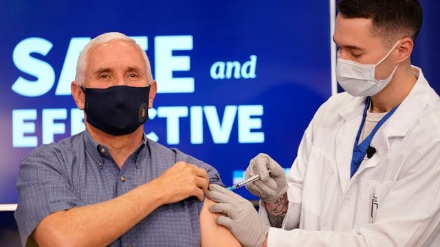 Der amtierende US-Vizepräsident Mike Pence (l) erhält eine Impfung mit dem Corona-Impfstoff von Pfizer-Biontech im Eisenhower Executive Office Building auf dem Gelände des Weißen Hauses.