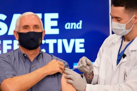 Der amtierende US-Vizepräsident Mike Pence (l) erhält eine Impfung mit dem Corona-Impfstoff von Pfizer-Biontech im Eisenhower Executive Office Building auf dem Gelände des Weißen Hauses.