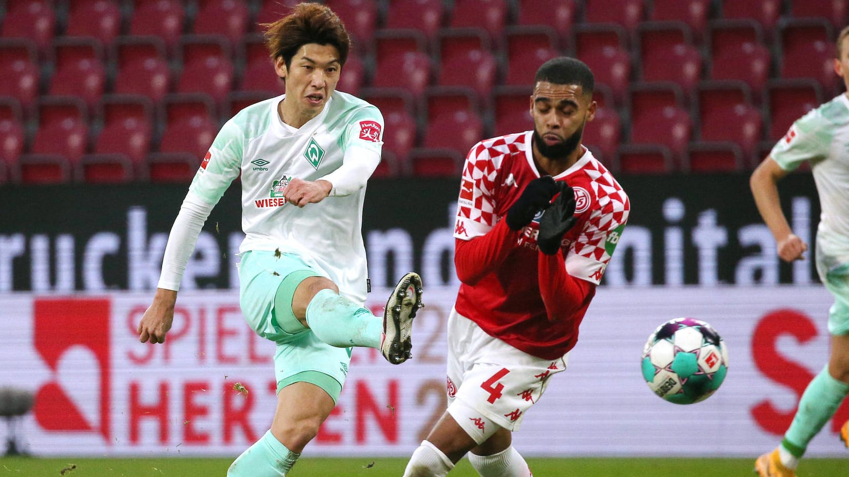 Bremens Yuya Osako (l.) bei einem Torversuch gegen Jeremiah St. Juste (r.) und Mainz 05.
