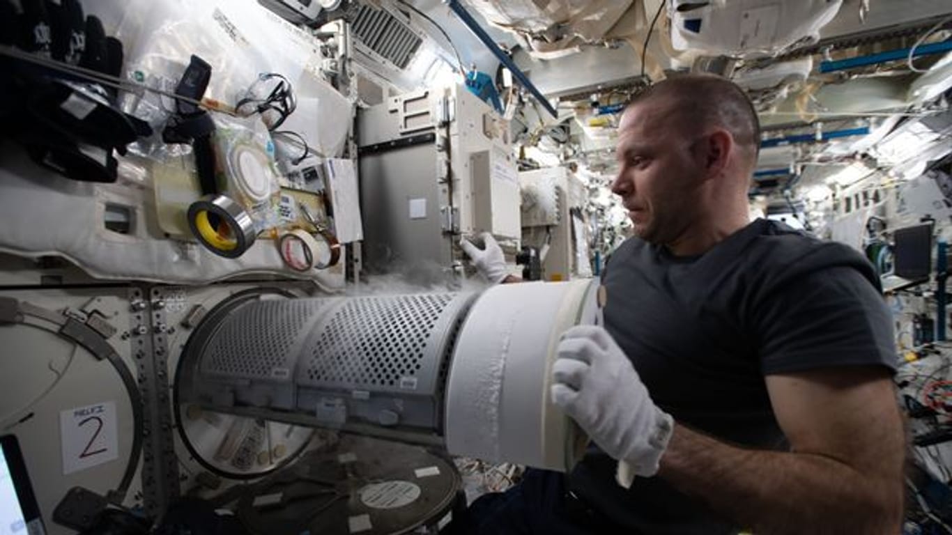 Der Kosmonaut Iwan Wagner überführt biologische Proben in einen wissenschaftlichen Gefrierschrank an Bord der Internationalen Raumstation (ISS).