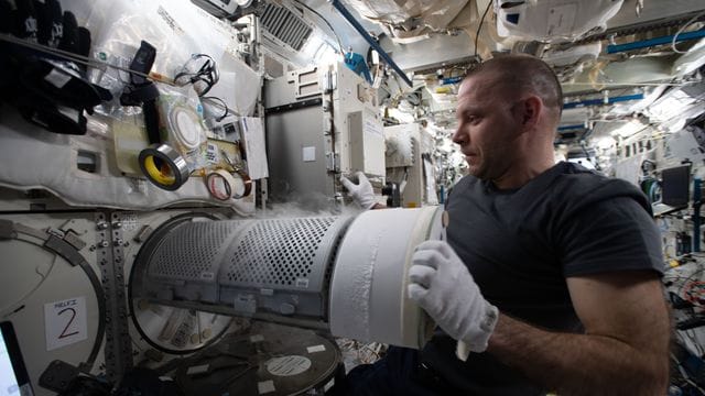 Der Kosmonaut Iwan Wagner überführt biologische Proben in einen wissenschaftlichen Gefrierschrank an Bord der Internationalen Raumstation (ISS). Der Kosmonaut Iwan Wagner überführt biologische Proben in einen wissenschaftlichen Gefrierschrank an Bord der Internationalen Raumstation (ISS).