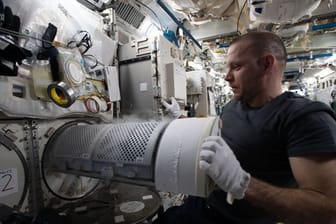 Der Kosmonaut Iwan Wagner überführt biologische Proben in einen wissenschaftlichen Gefrierschrank an Bord der Internationalen Raumstation (ISS).