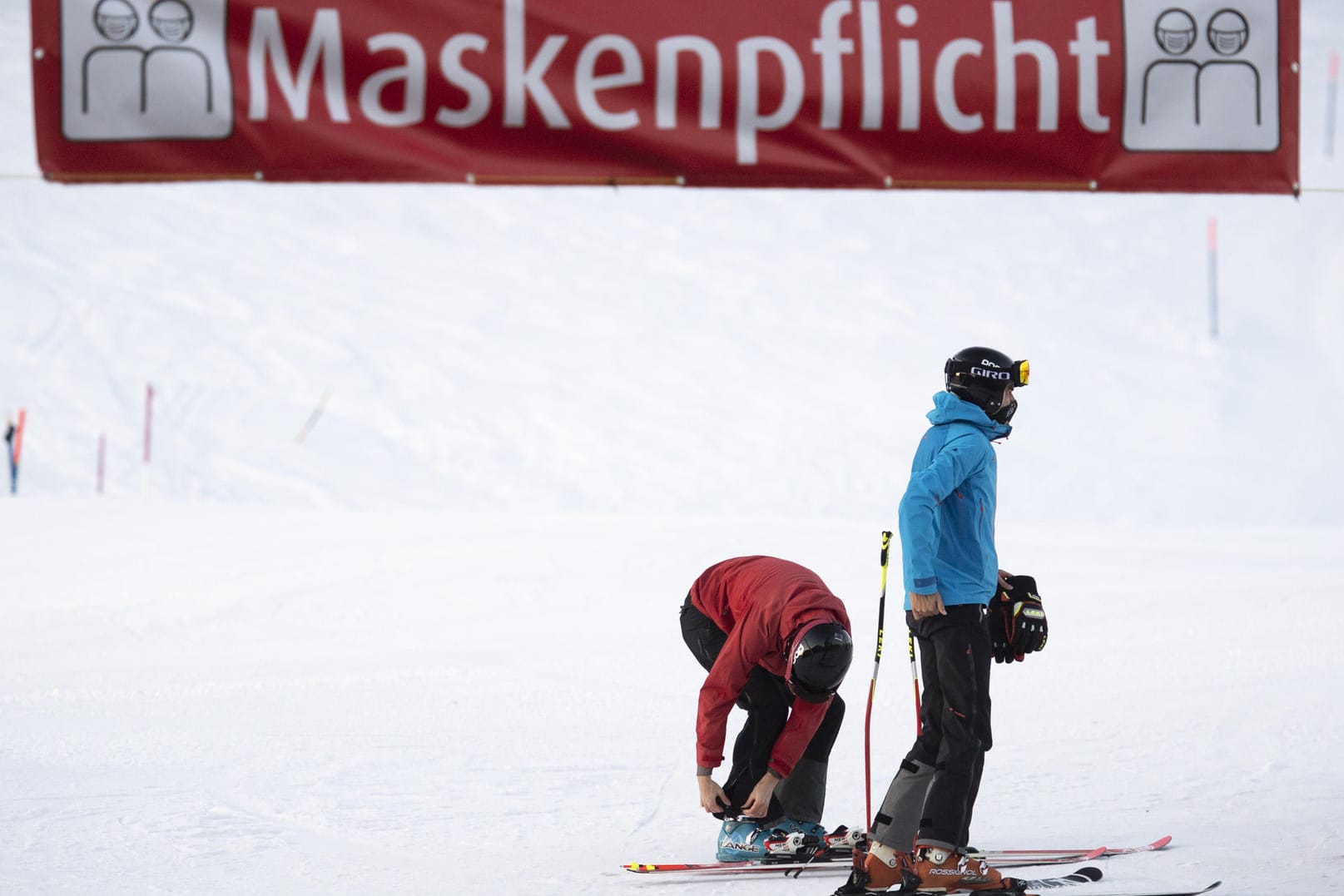 Skifahrer unter einem Maskenpflicht-Banner im Schweizer Skigebiet Flumserberg: Auch dort endet der Sportbetrieb am Dienstag.