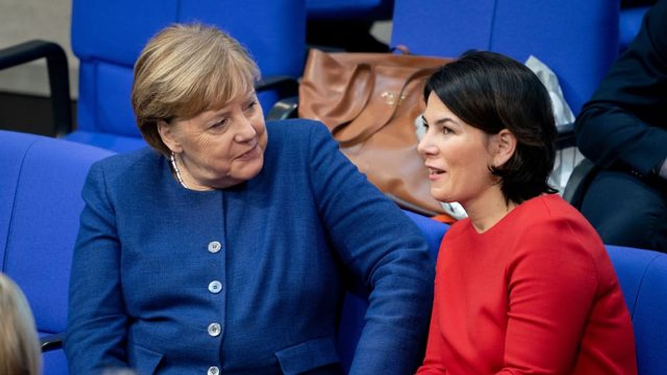 Begegnung im Bundestag: Bundeskanzlerin Angela Merkel (l, CDU) und Annalena Baerbock, Bundesvorsitzende von Bündnis 90/Die Grünen, während einer Sitzung zu Jahresbeginn.