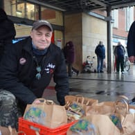 Peter Könnecke steht mit gepackten Tüten vor dem Kieler Hauptbahnhof: Etwa 60 bis 100 Obdachlose kommen zur Lebensmittelausgabe.